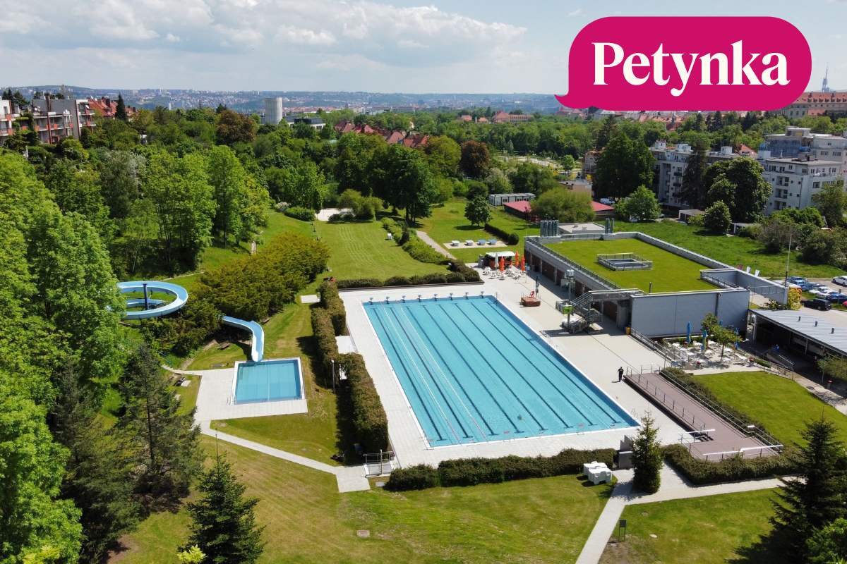 Letecký pohled na venkovní bazén a travnaté plochy letního koupaliště Petynka v Praze 6.